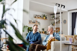 Infirmier avec un client à domicile, illustrant les services de soins aux aînés adaptés aux besoins.