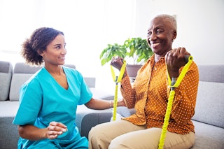 Cliente recevant un soutien physique à domicile, illustrant les avantages des soins à domicile pour les aînés.