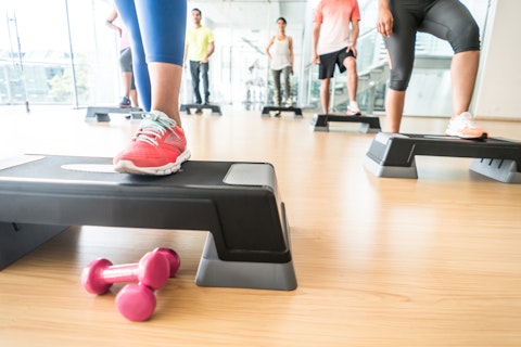 Unrecognizable group of people at the gym in an aerobics class with steps â healthy lifestyle concepts